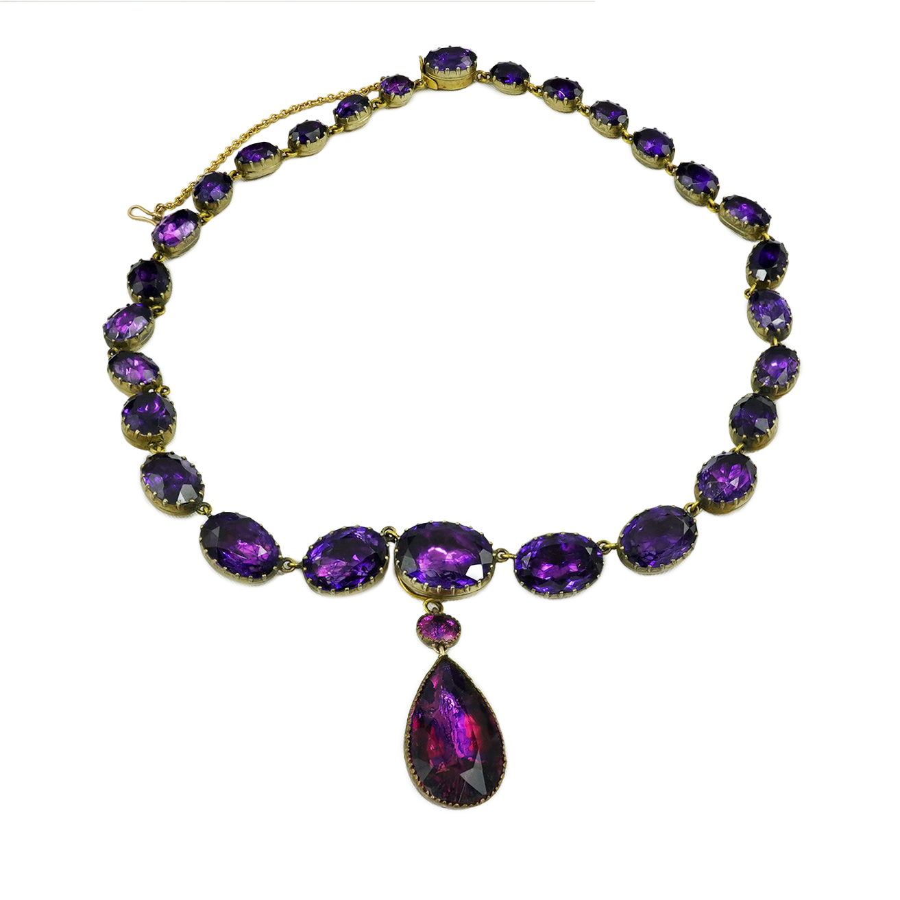 A Georgian gilt metal and graduated foil backed oval cut amethyst paste set riviere drop necklace